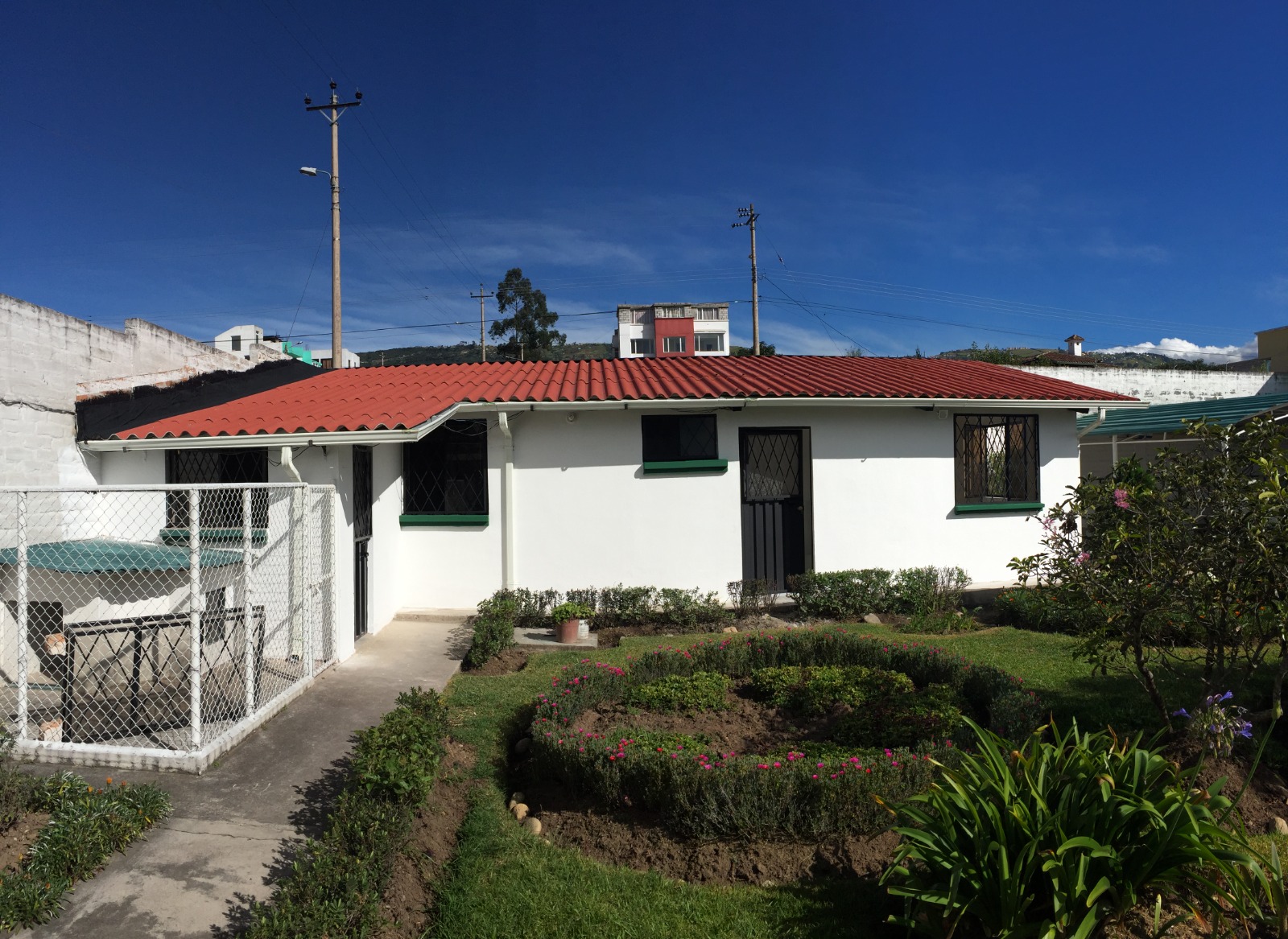 Vivienda unifamiliar con techo rojo y jardín ornamental terminado