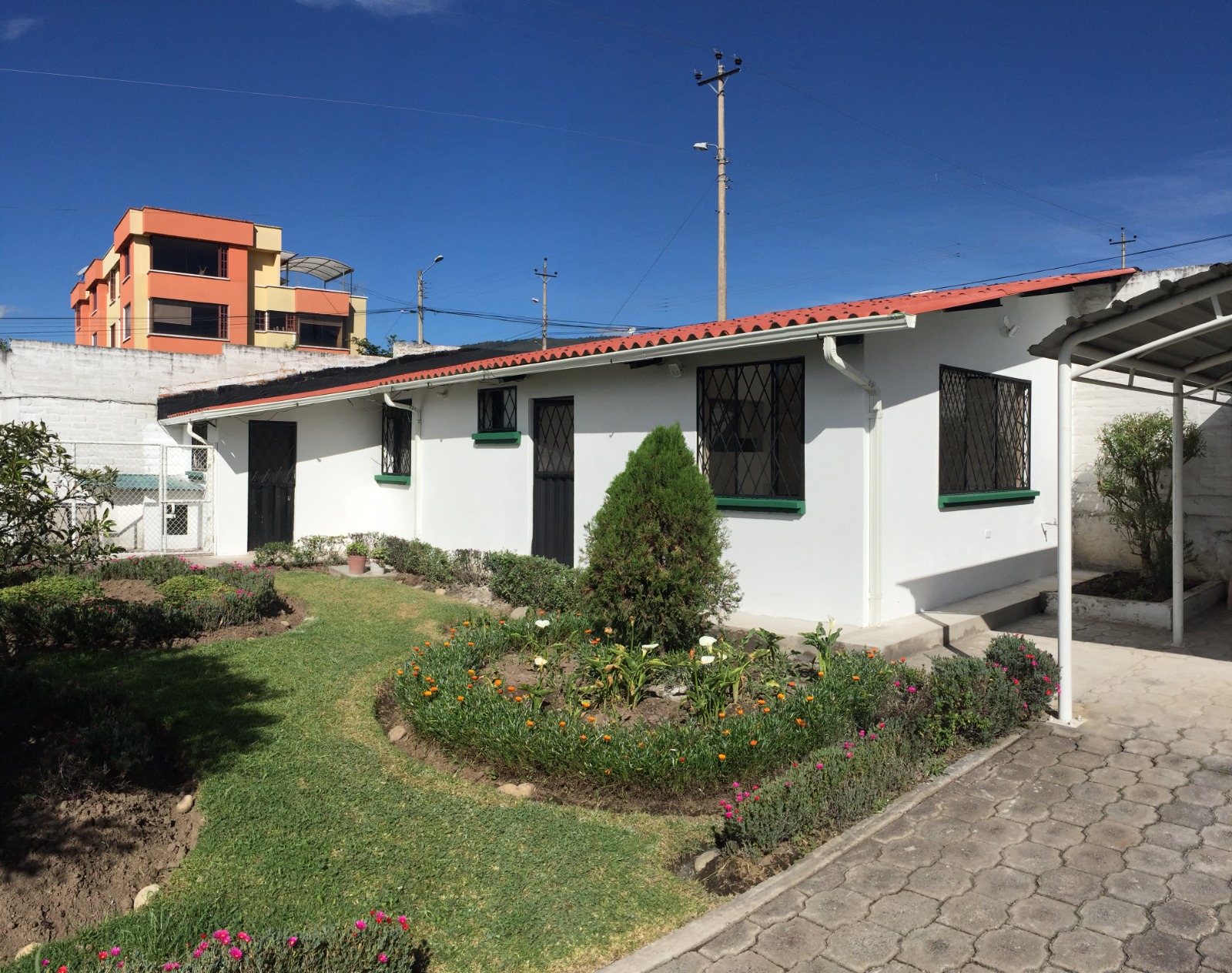 Casa con jardín de flores y acabados exteriores entregada al cliente